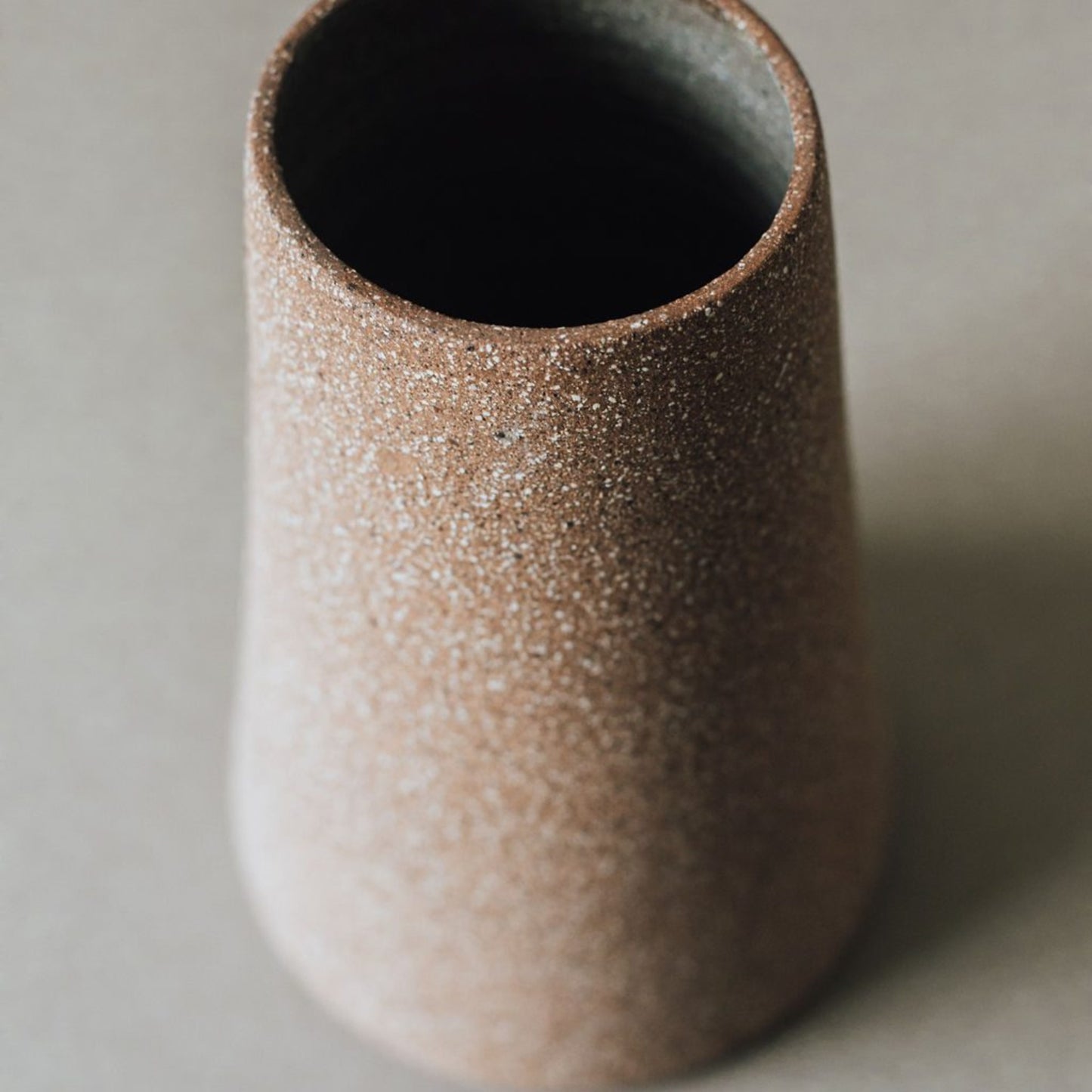 Close up of cork terracotta ceramic vase showing transparent glazed interior and raw clay exterior
