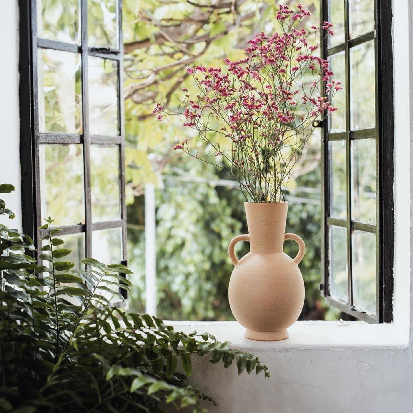 Natural sand ceramic vase styled by window in neutral interior