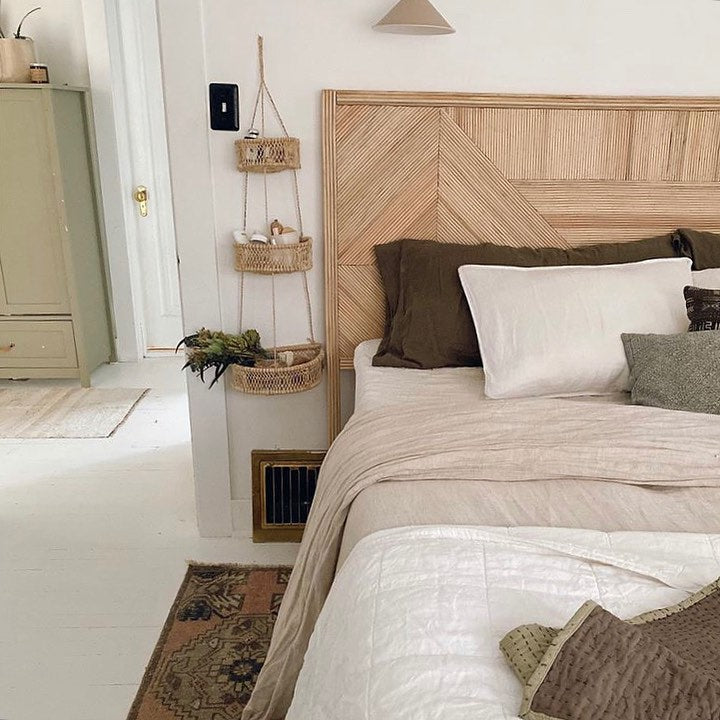 Bedroom with a three-tier woven hanging basket beside a wooden headboard