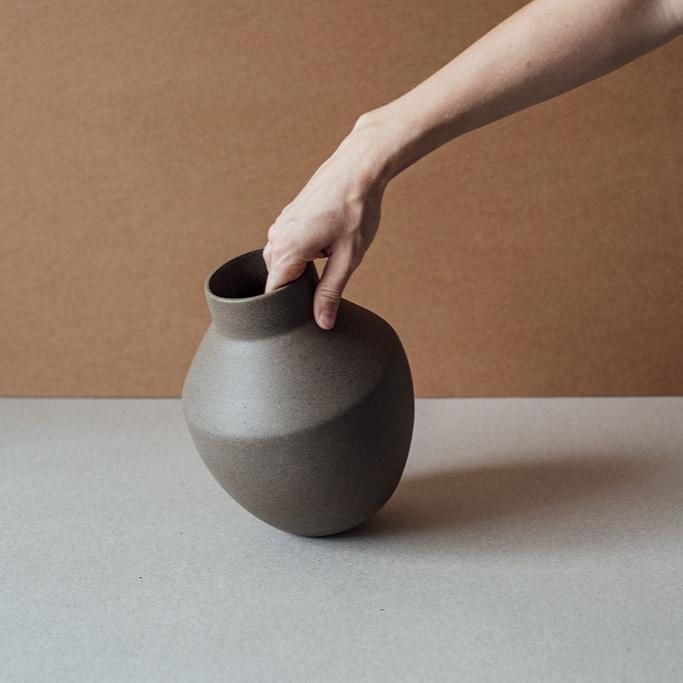 Side view of minimalist terracotta vase highlighting smooth matte finish.