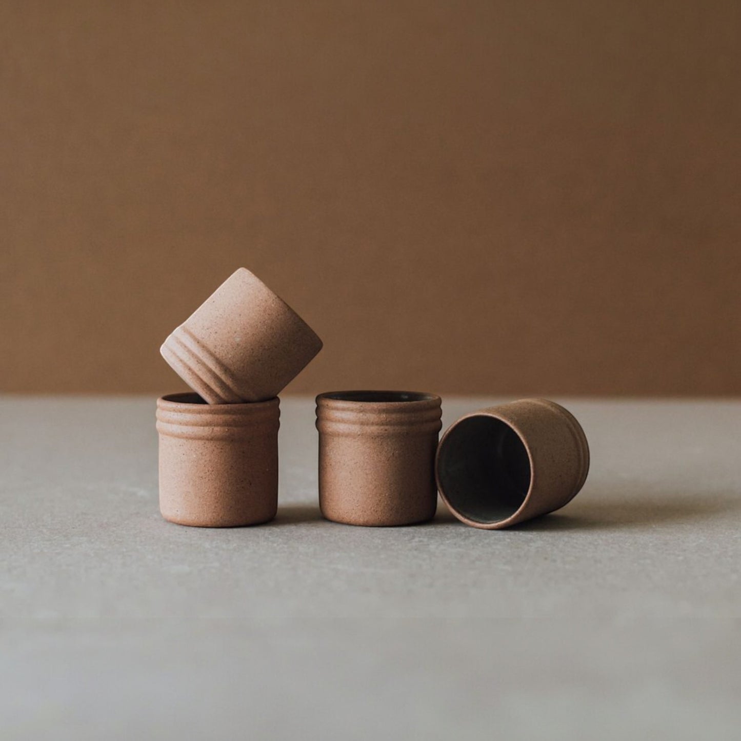 Handmade Mexican stoneware shot glasses for mezcal or tequila stacked to show glaze and natural clay texture.