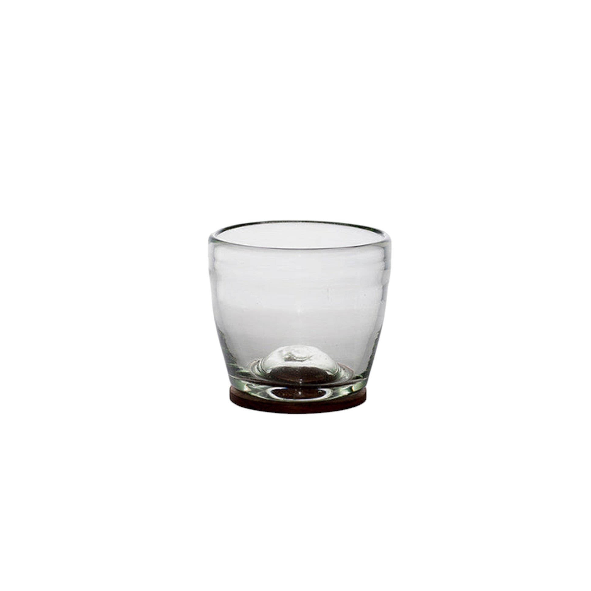 Single clear hand-blown glass tumbler with a rounded wooden base on a white background.