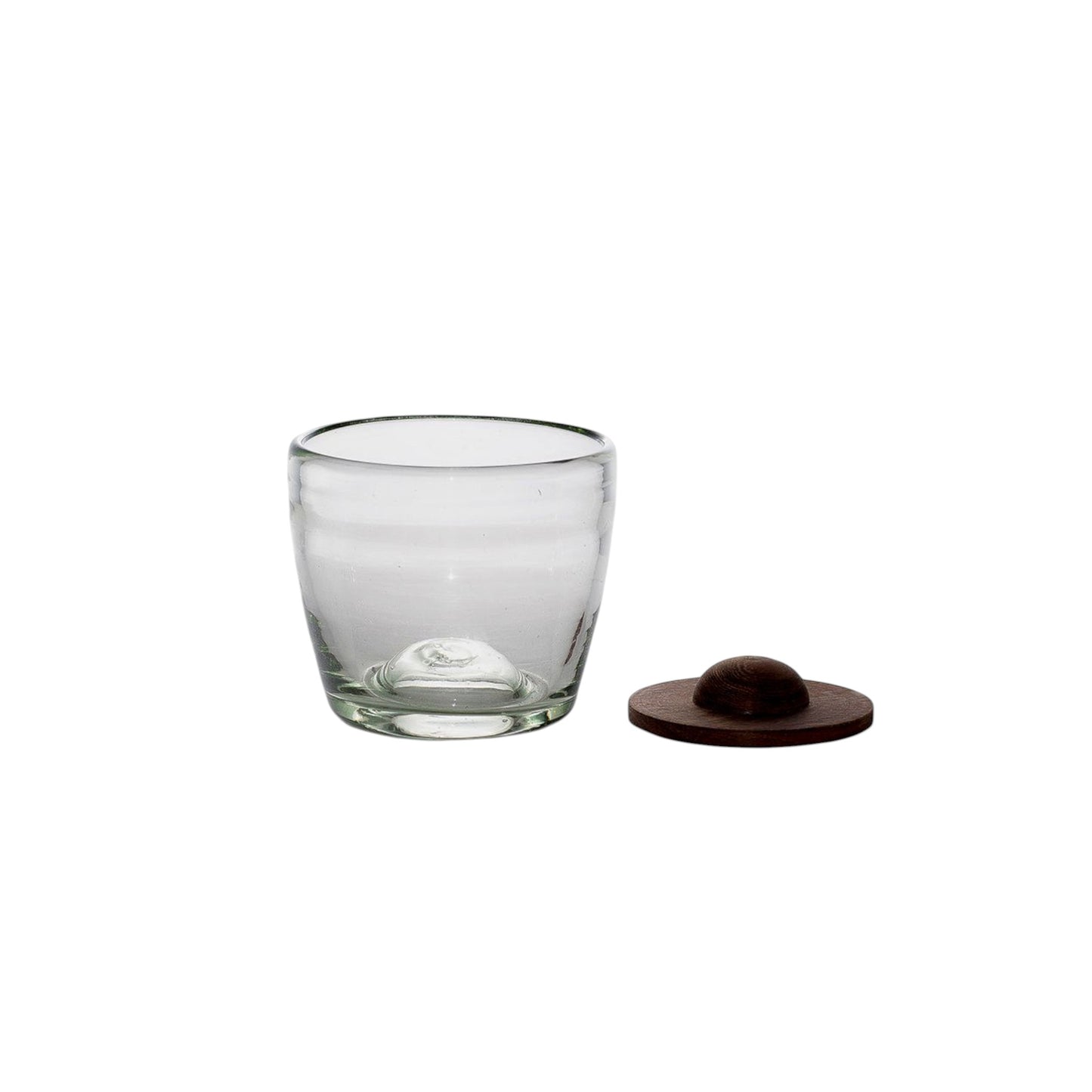 Clear glass tumbler with a dark brown wooden coaster on a white background.