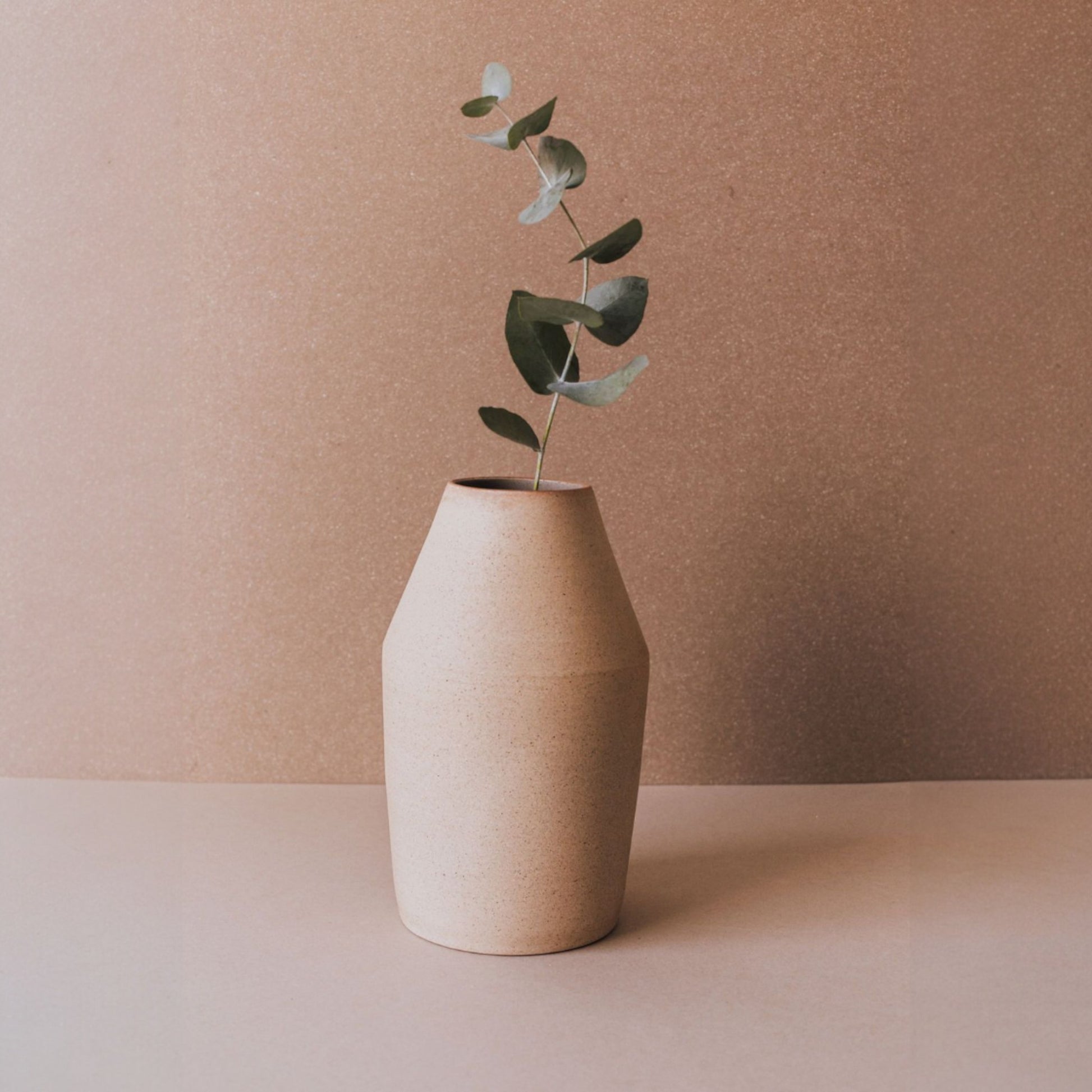 Handmade conical sand ceramic vase with eucalyptus stem, minimalist sculptural pottery from Mexico