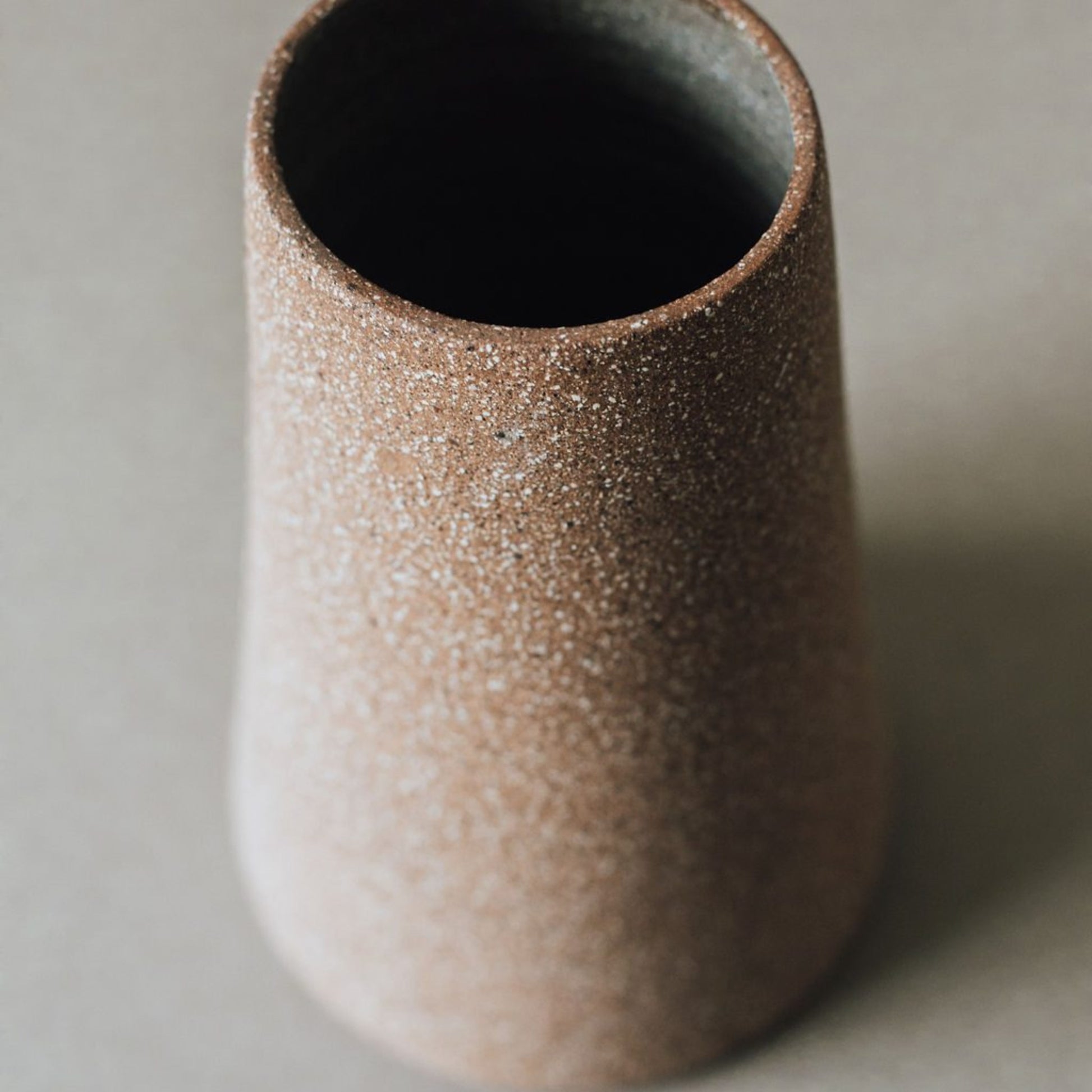 Close up of cork terracotta ceramic vase showing transparent glazed interior and raw clay exterior