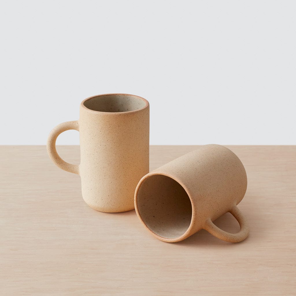 Tall stoneware mug lying on its side to display the glazed interior and raw matte exterior.