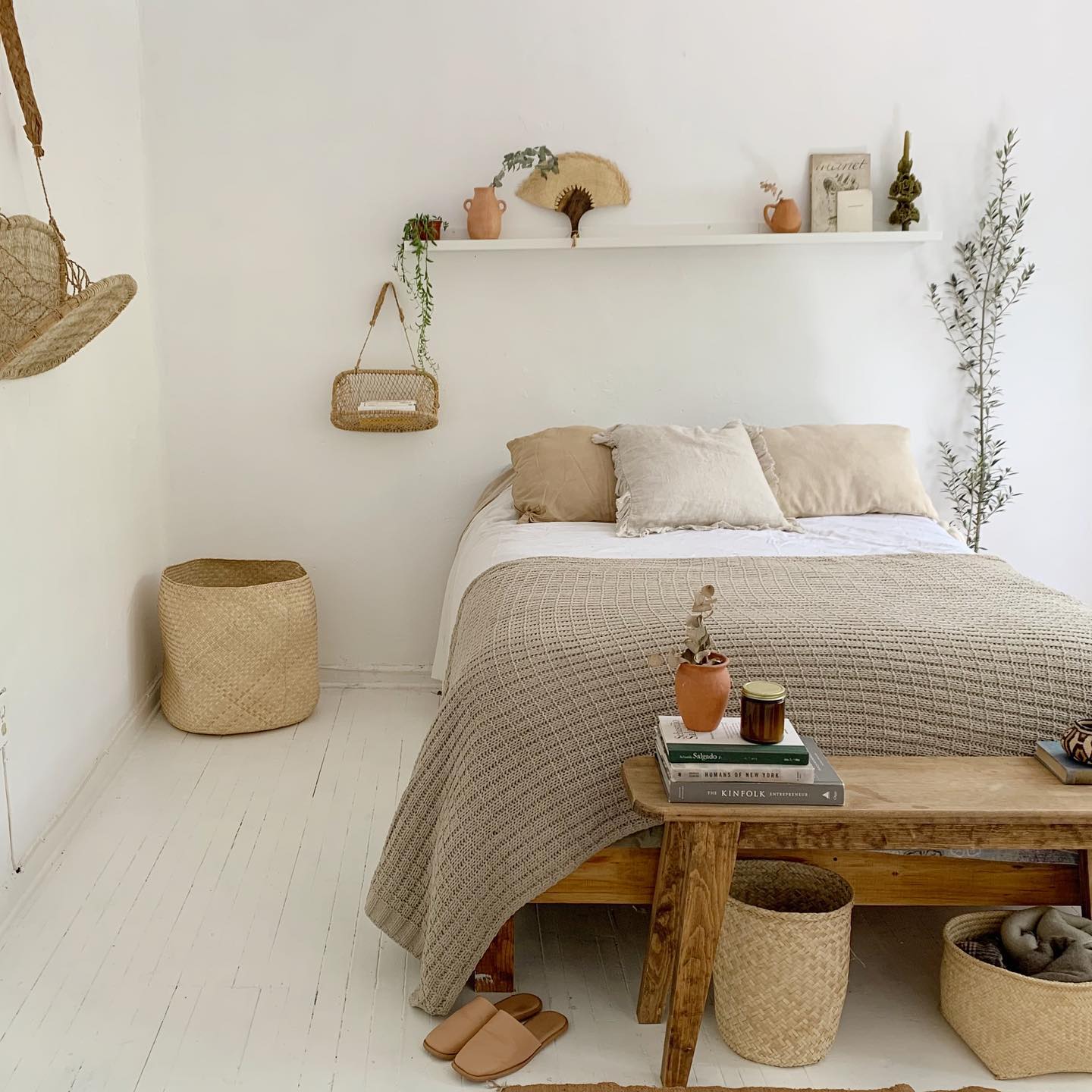Cozy bedroom with a small jonote hanging basket displayed above the bed as wall decor.