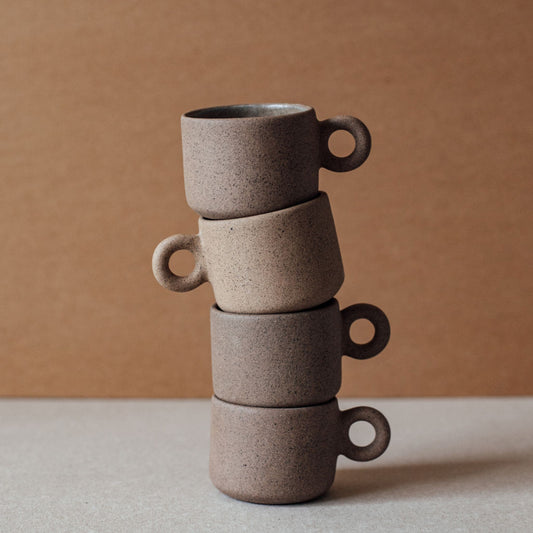 Stack of four terracotta ring cups with circular handles, sculptural minimalist ceramic drinkware