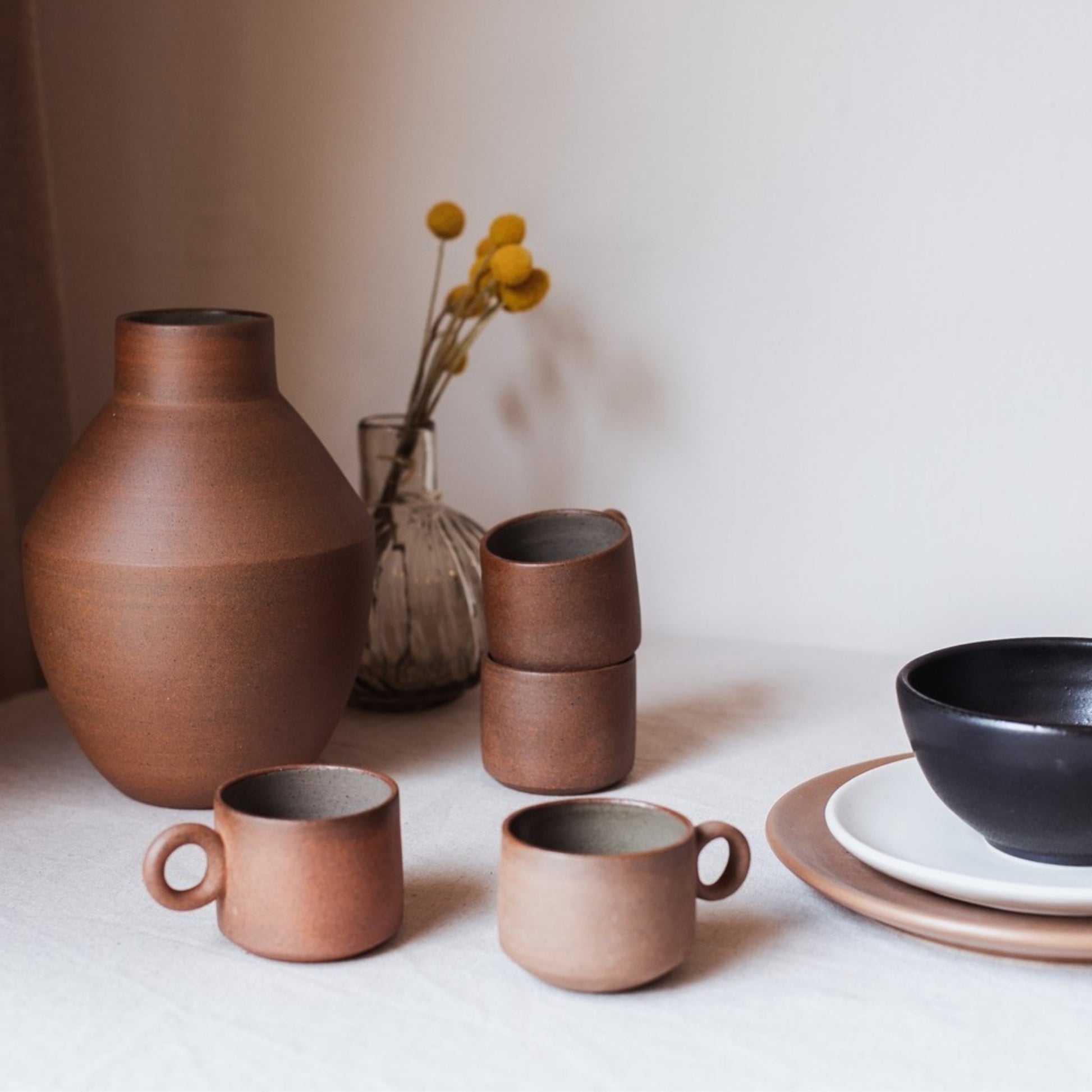 Handmade terracotta ring cup styled with vase and plates, earthy minimalist table setting