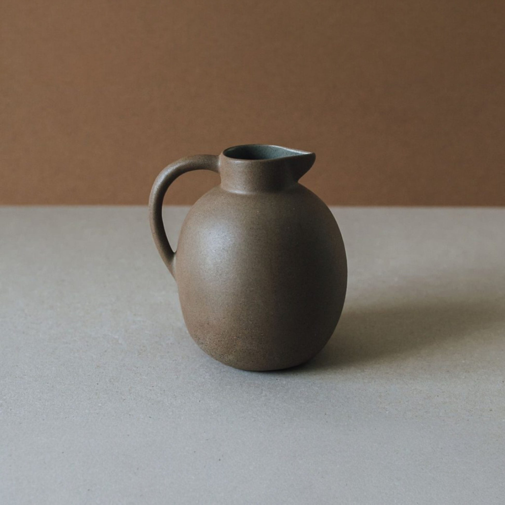 Handmade terracotta clay jug with ergonomic handle and glazed interior