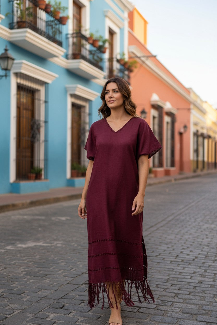 Burgundy silk blend kaftan dress styled on a colonial street in Mexico, relaxed fit and V-neckline