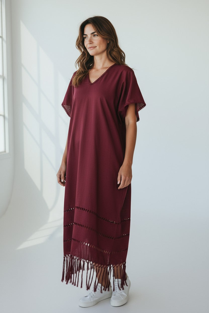 Burgundy silk blend kaftan dress with artisan open-weave details and fringe hem, front studio view