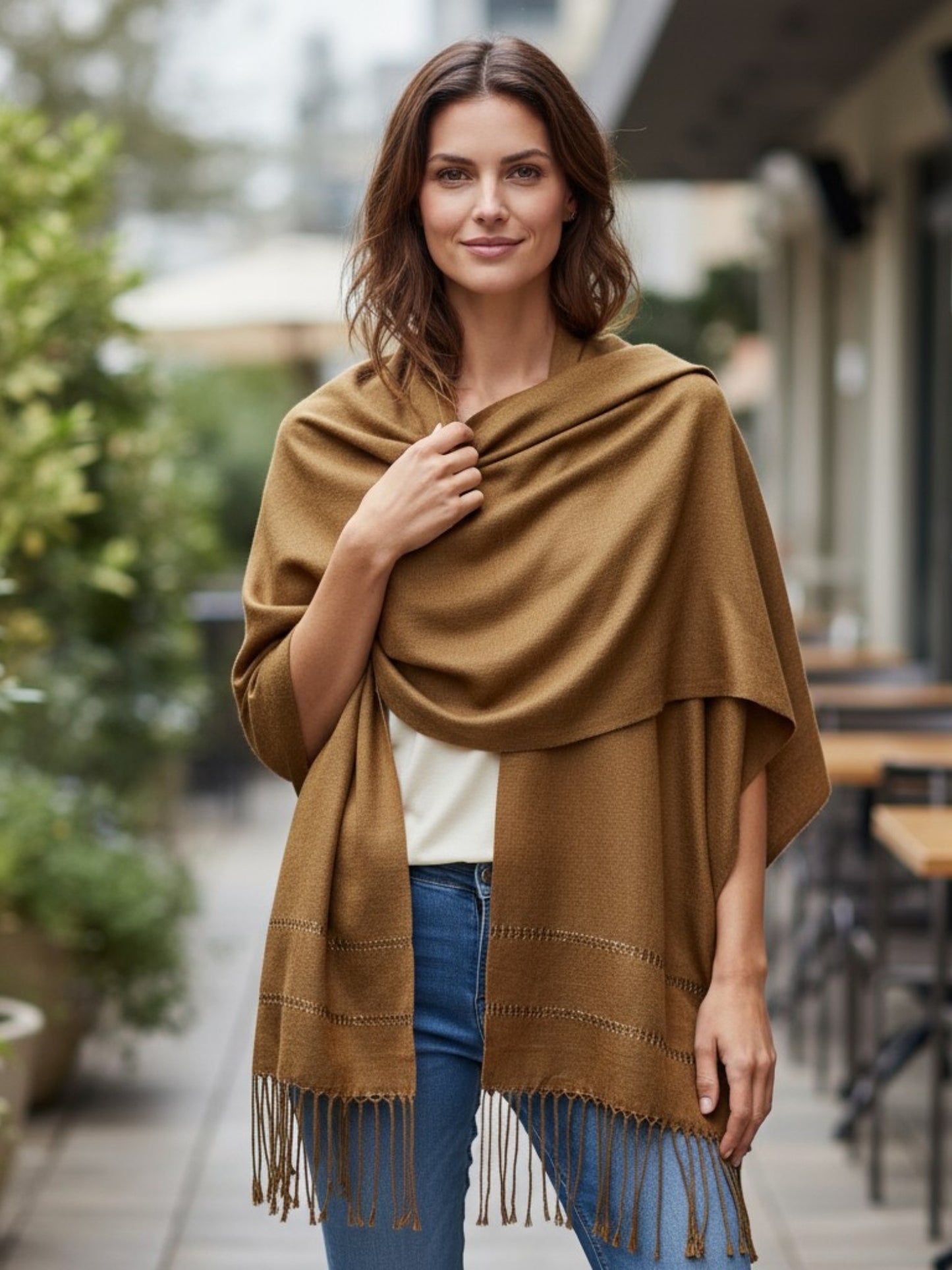 Gold silk-blend rebozo shawl wrapped over shoulders near café seating