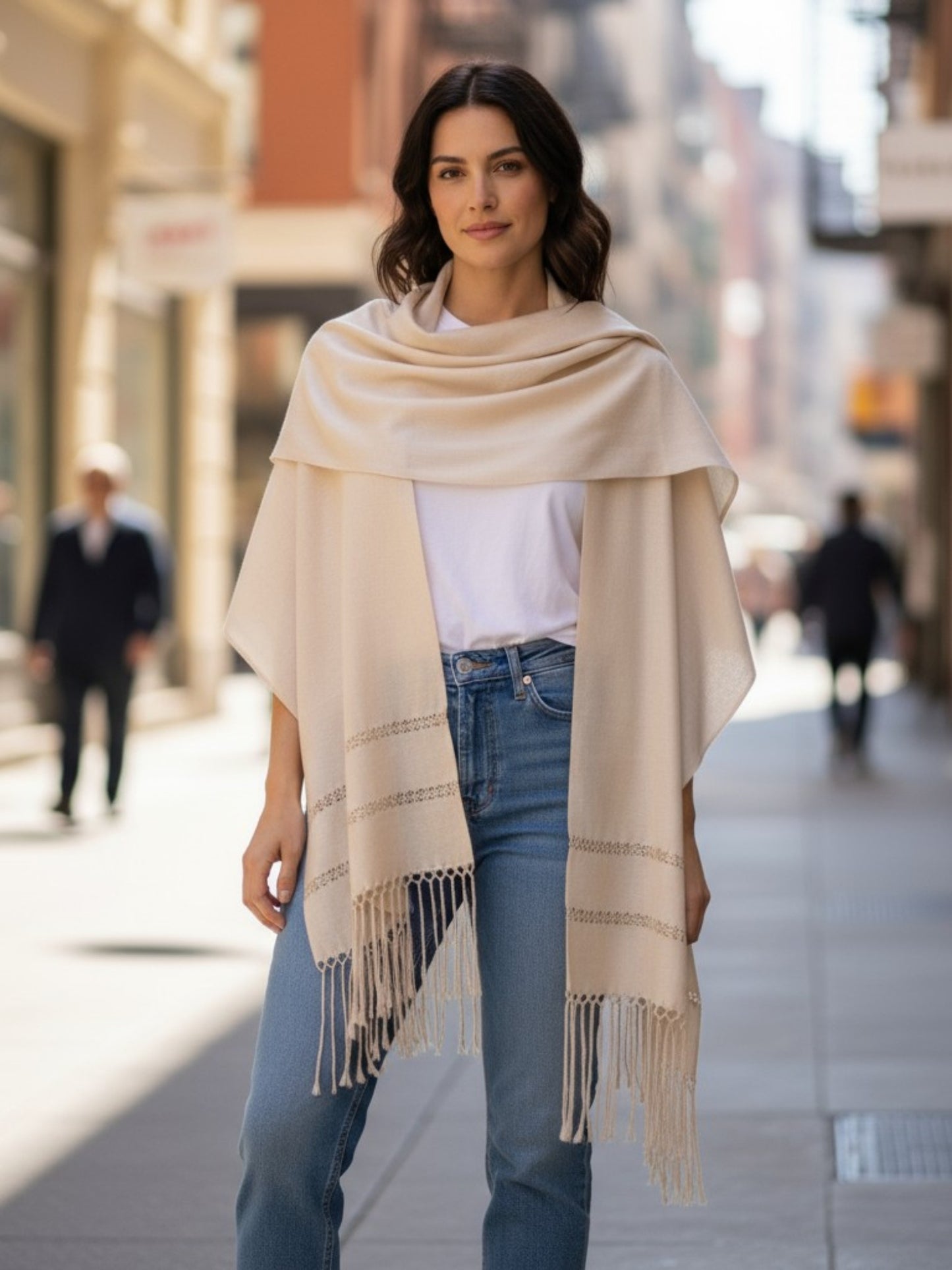 Silk-blend rebozo shawl in ivory draped over shoulders on city street