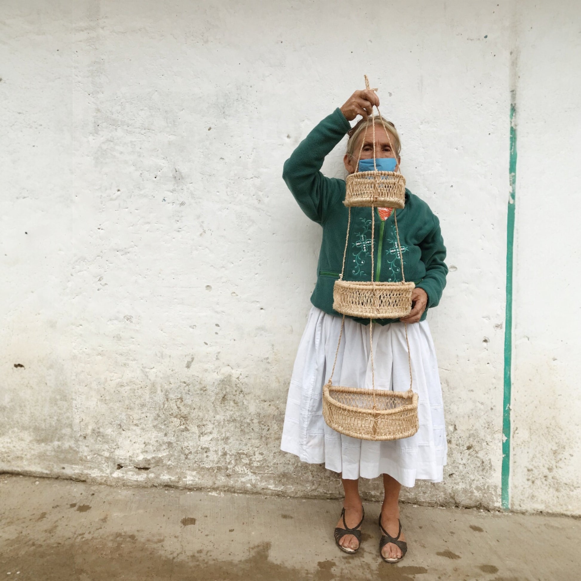 Artisan woman holding a three-tier jonote hanging basket
