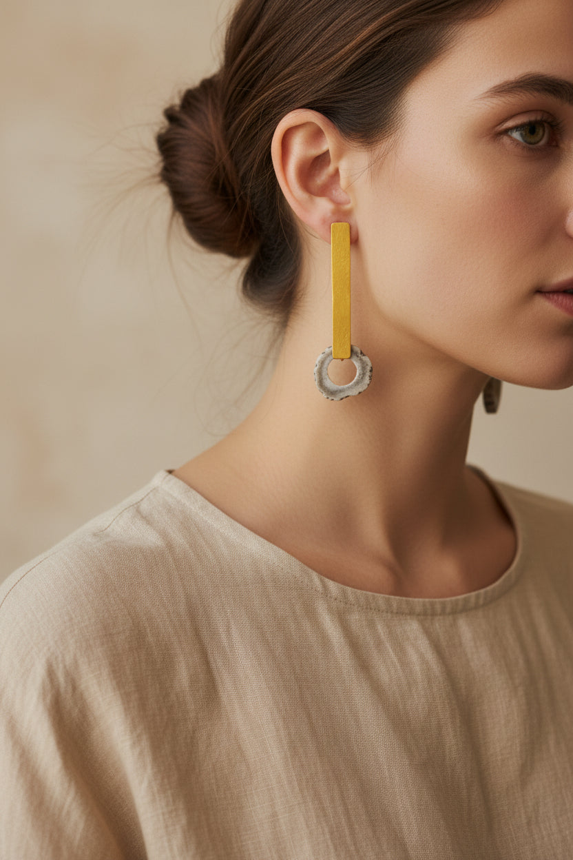 Woman wearing gold horn bar drop earrings, natural makeup, front view
