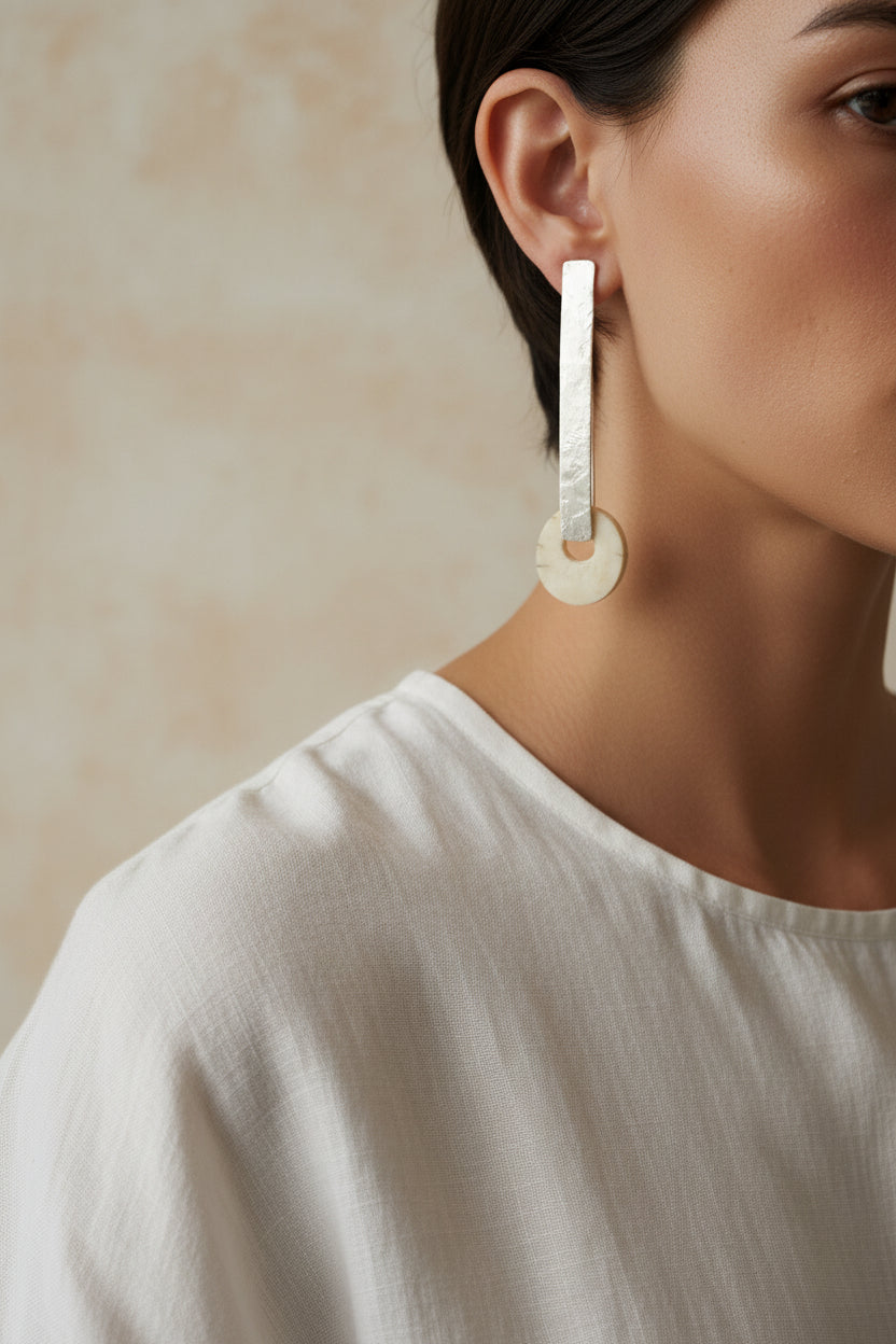 Close-up of silver horn bar drop earring worn on ear, detail shot
