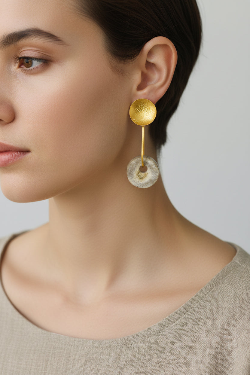 Pair of silver-plated horn disc drop earrings on white background, sculptural metal top with natural deer antler disc