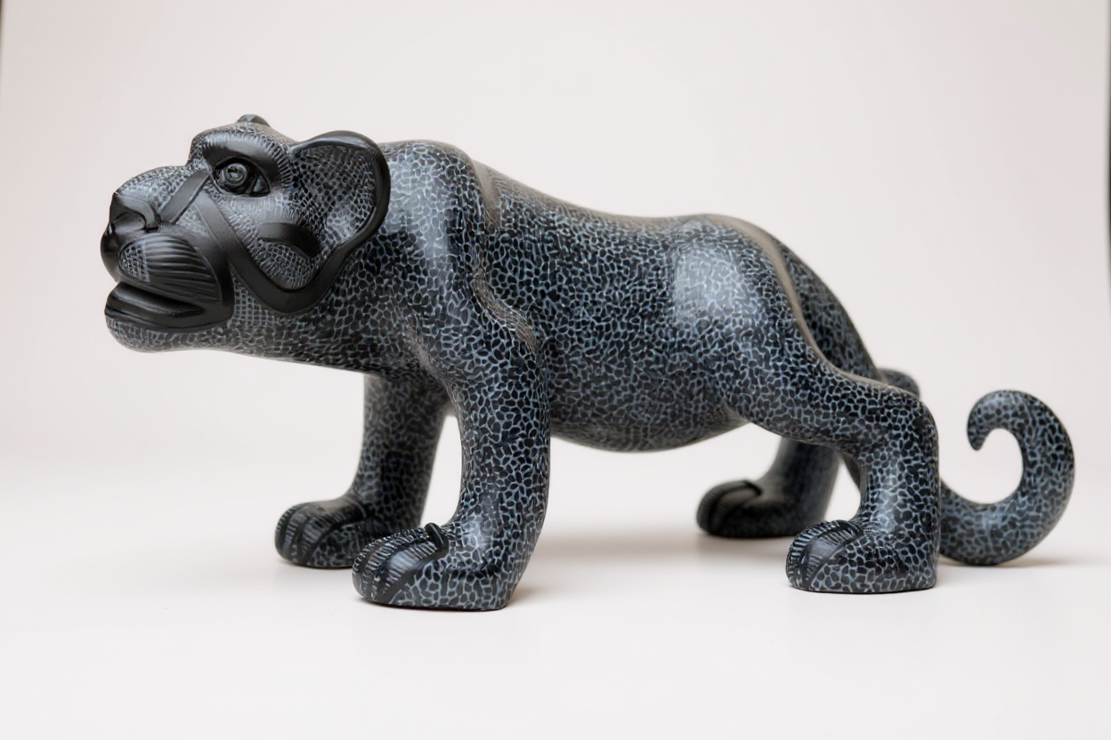 A hand-painted black ceramic Mayan jaguar sculpture in a standing pose displayed against a clean white background.