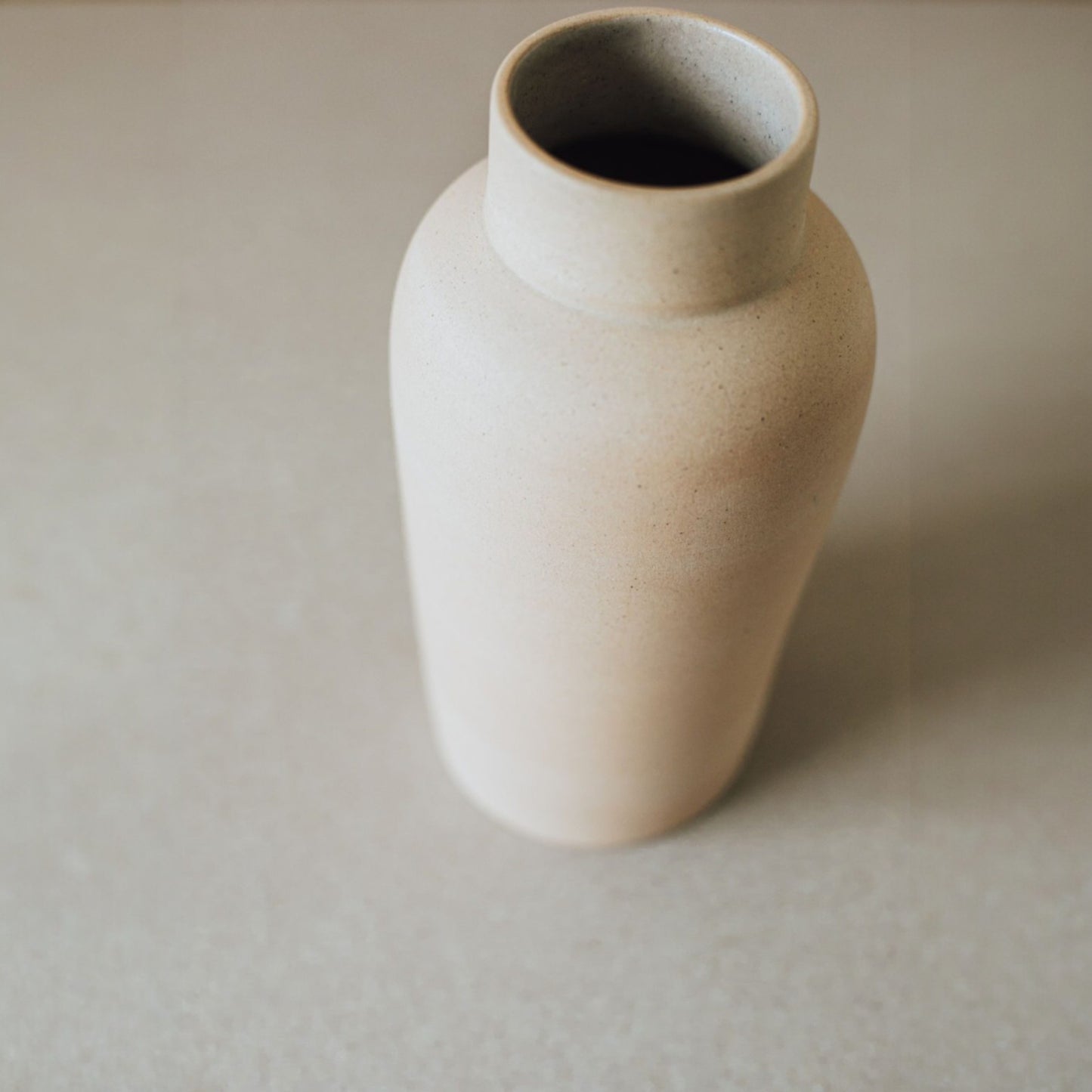 Sand terracotta vase showing its rounded bottle silhouette.