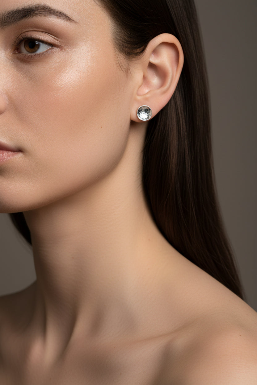 Handmade silver dome stud earrings worn by a woman against a neutral background