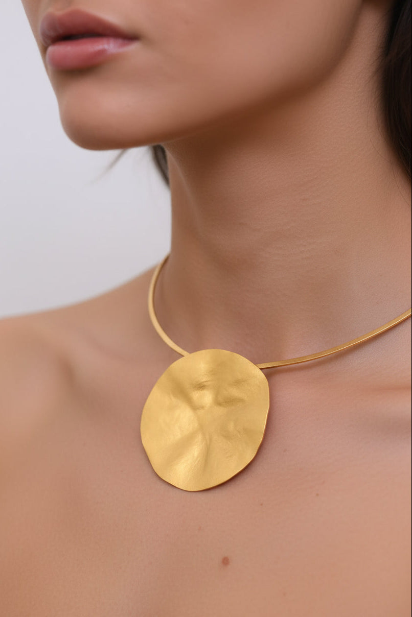 Gold hammered moon pendant choker worn on model, close-up neck view