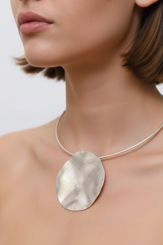 Silver hammered moon pendant choker worn on model, close-up neck view