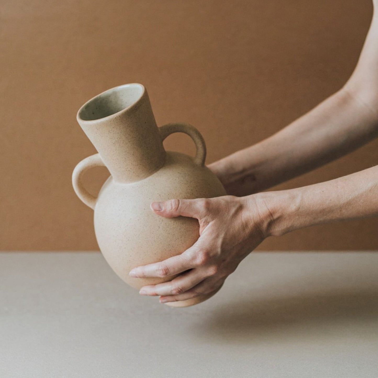 Sculptural ceramic urn vase with elongated neck and handles