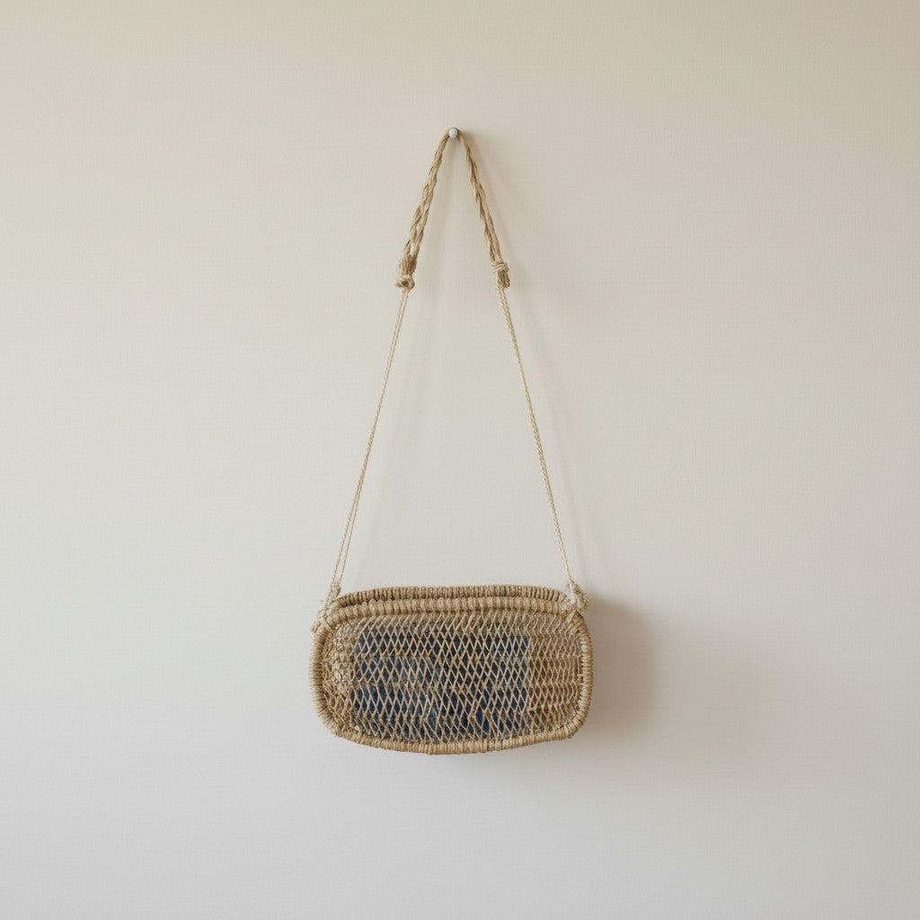 Rectangular woven wall basket hanging on a white wall