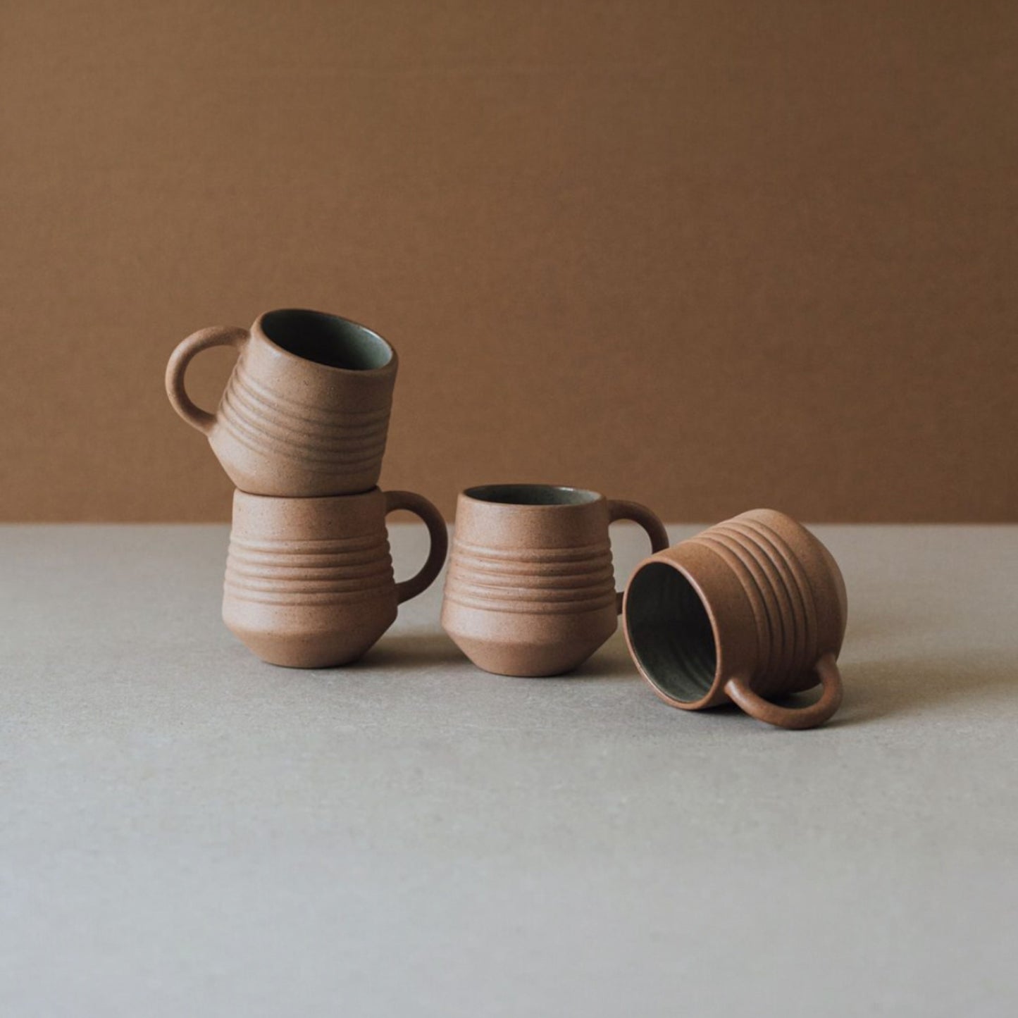 Ridge terracotta mug set styled with matching ceramic vase and cups in warm earthy tones