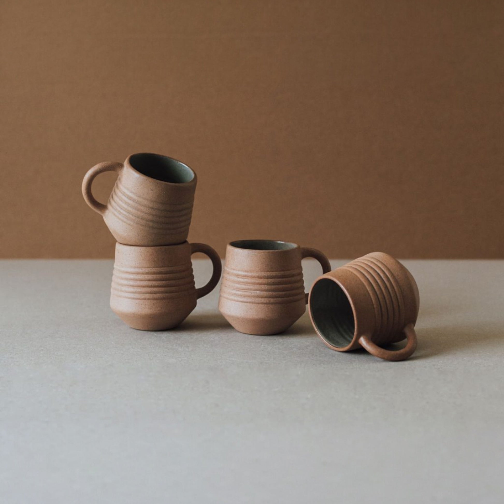 Ridge terracotta mug set styled with matching ceramic vase and cups in warm earthy tones