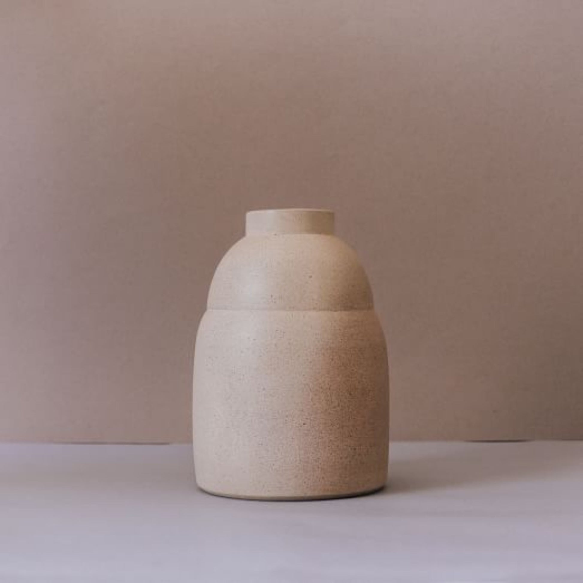 Back view of rounded handmade ceramic vase in natural light terracotta finish
