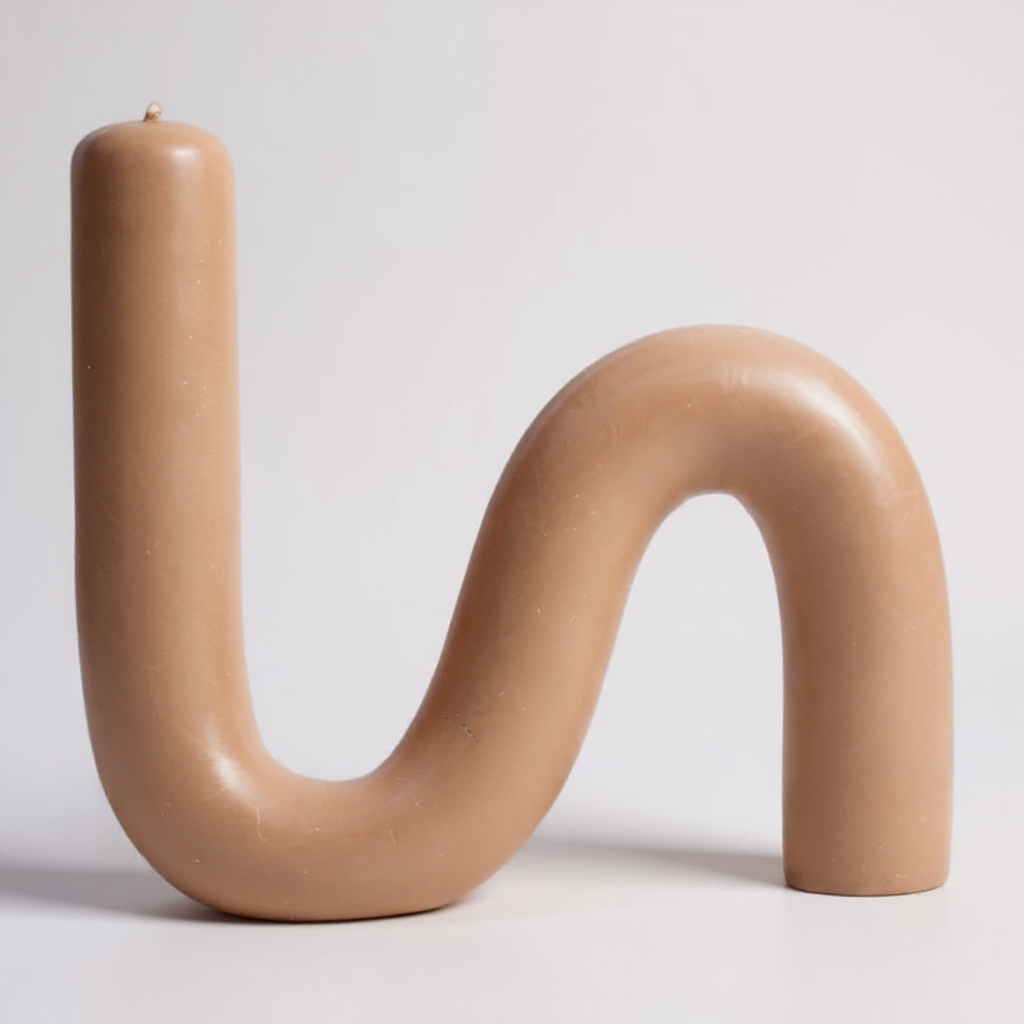 Close-up of a single S-shaped beeswax candle in natural sand color