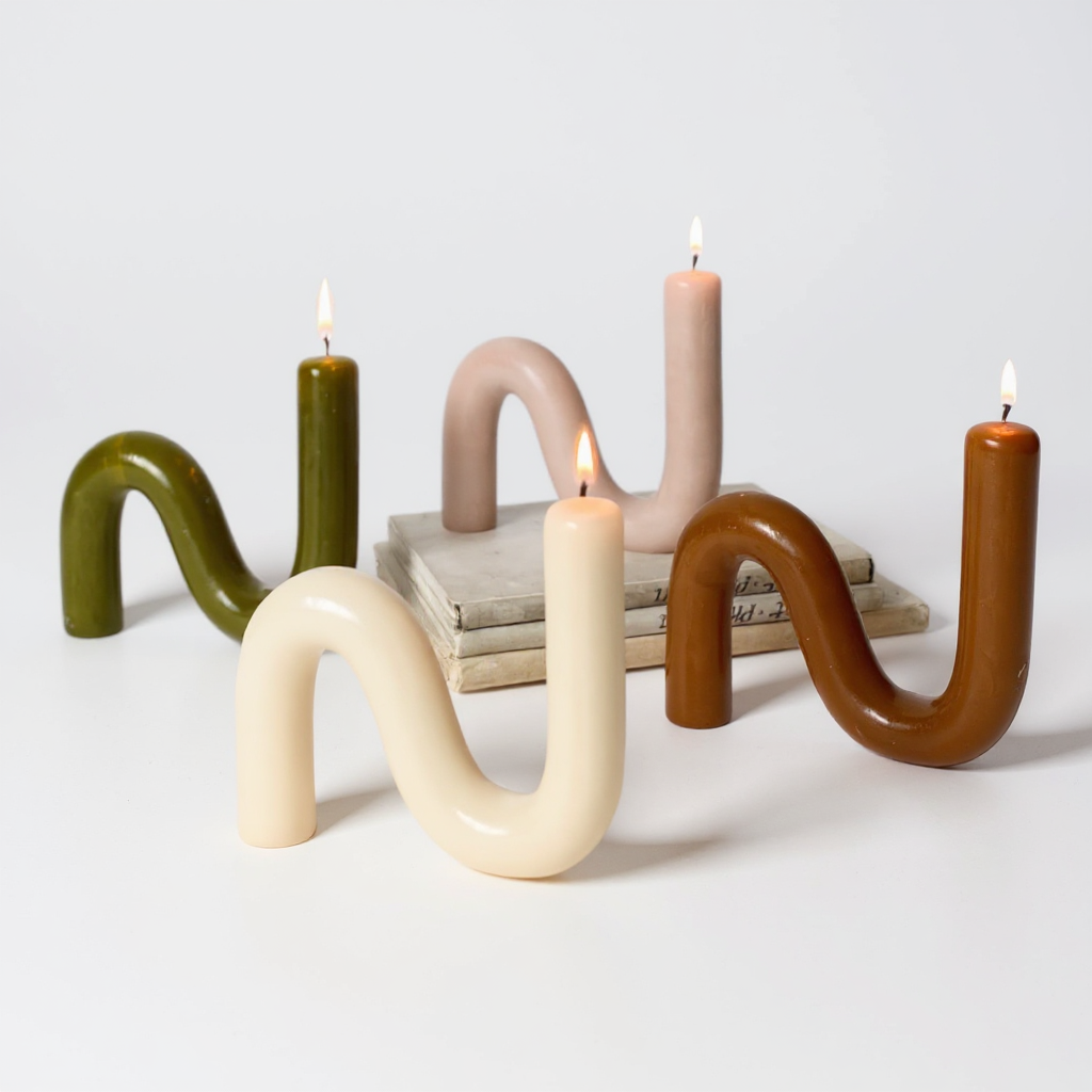 Curved S-shaped beeswax candles in assorted neutral tones on a white background