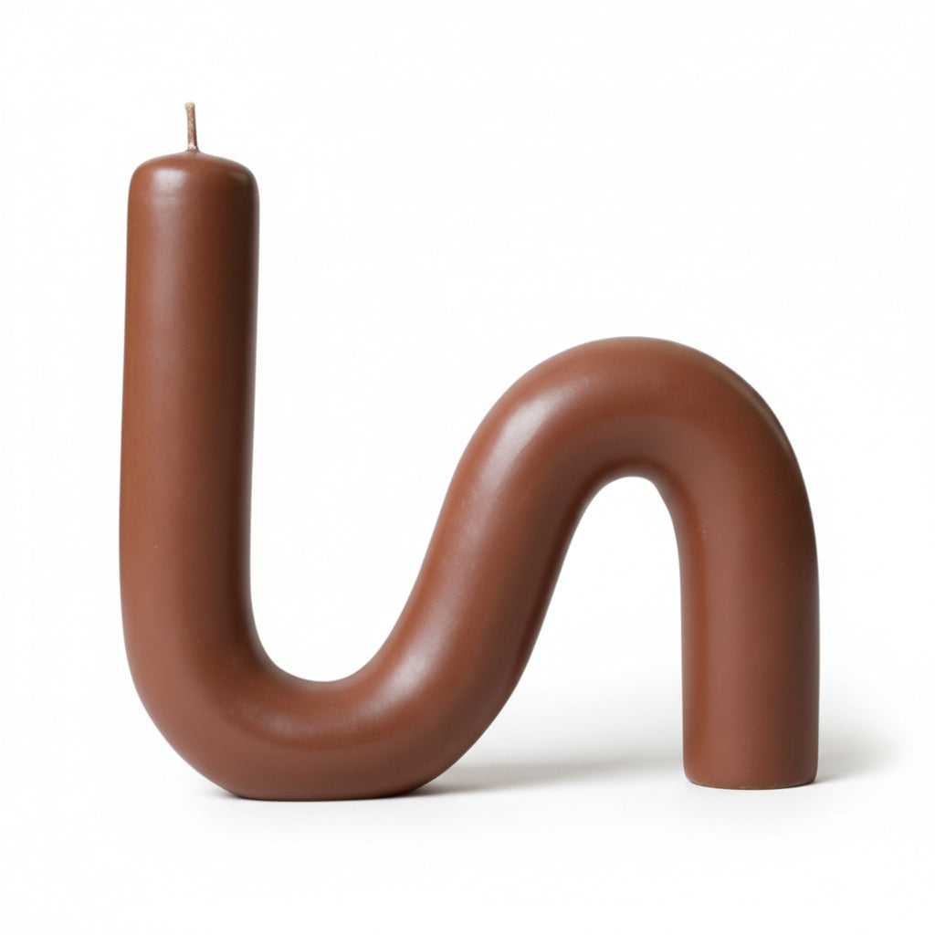 S-shaped beeswax candle in caramel color on a white background