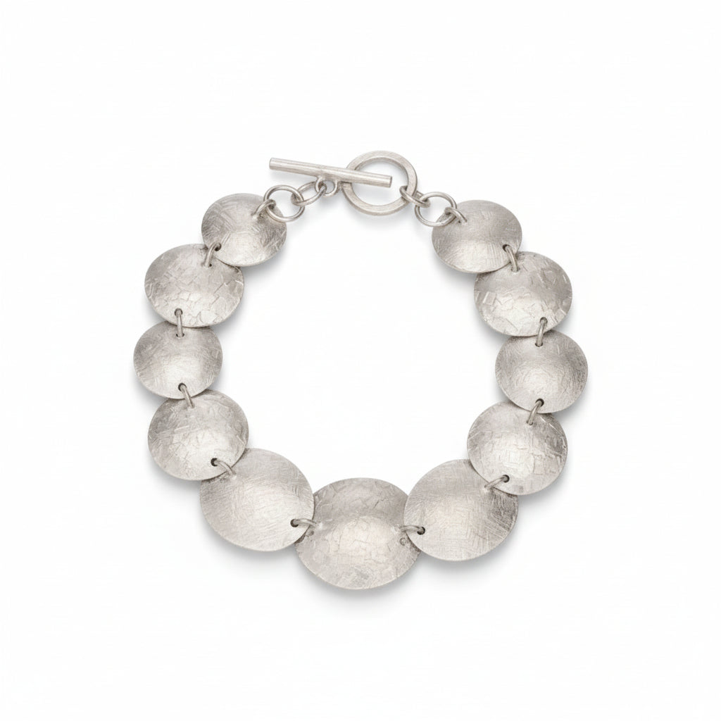 Sculpted disc bracelet in sterling silver, product flat lay on white background