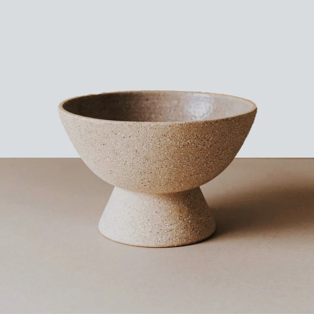 Terracotta pedestal fruit bowl with wide shallow shape and flared base, minimalist rustic ceramic centerpiece