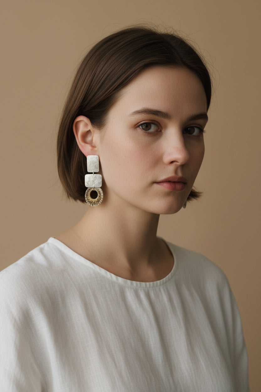 Model wearing silver square deer horn drop earrings with linen top, front portrait