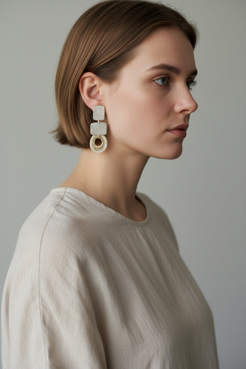 Model wearing silver square deer horn drop earrings with linen top, side profile view