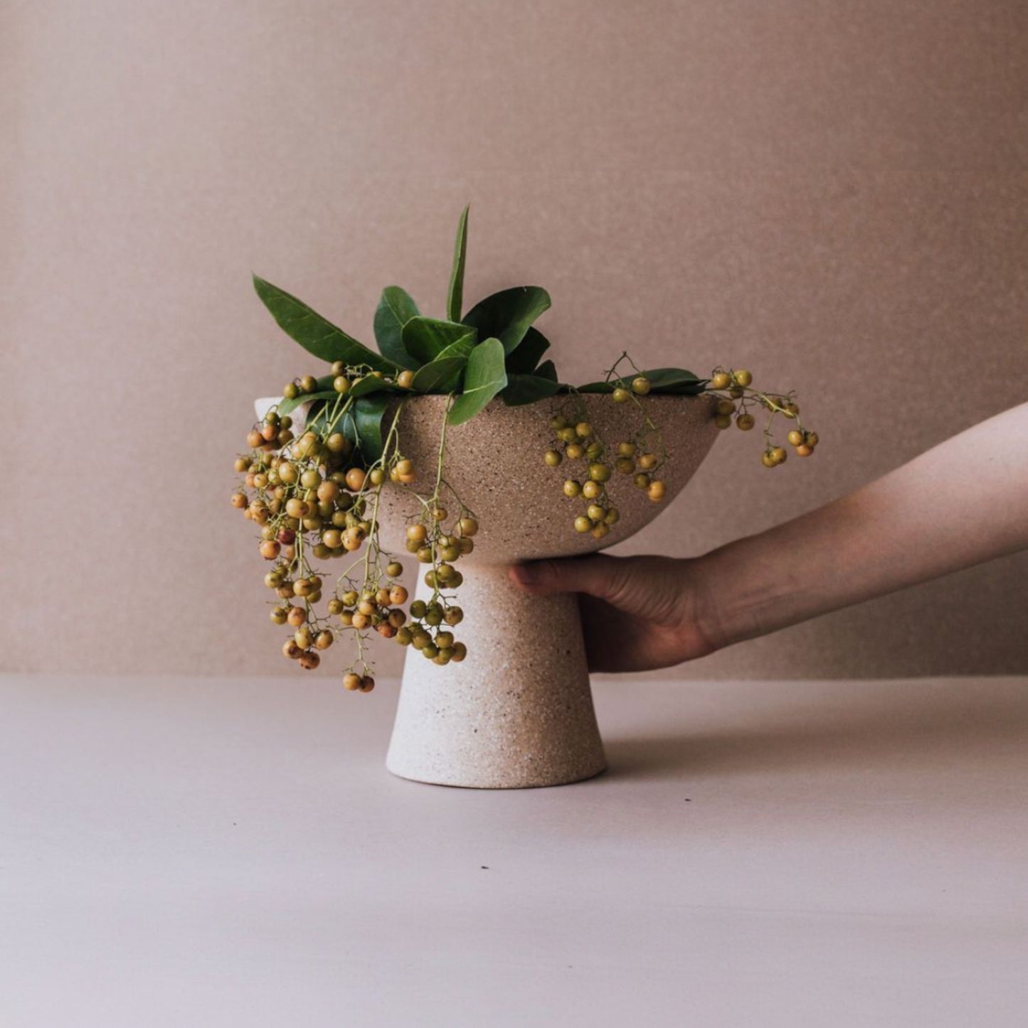 Tall handmade ceramic pedestal bowl with natural greenery for dining table decor