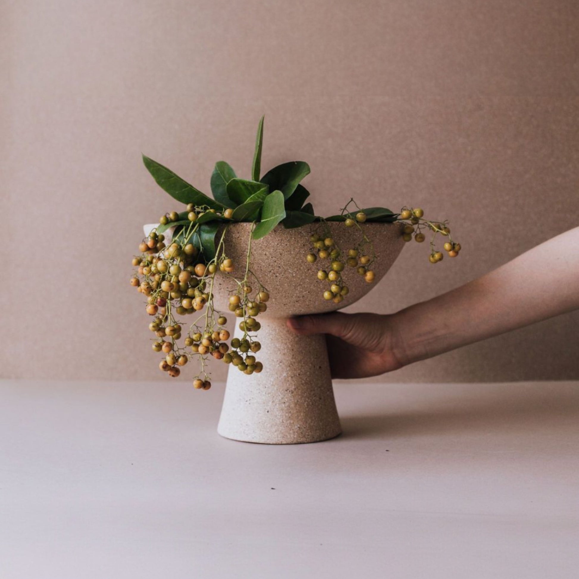 Tall handmade ceramic pedestal bowl with natural greenery for dining table decor