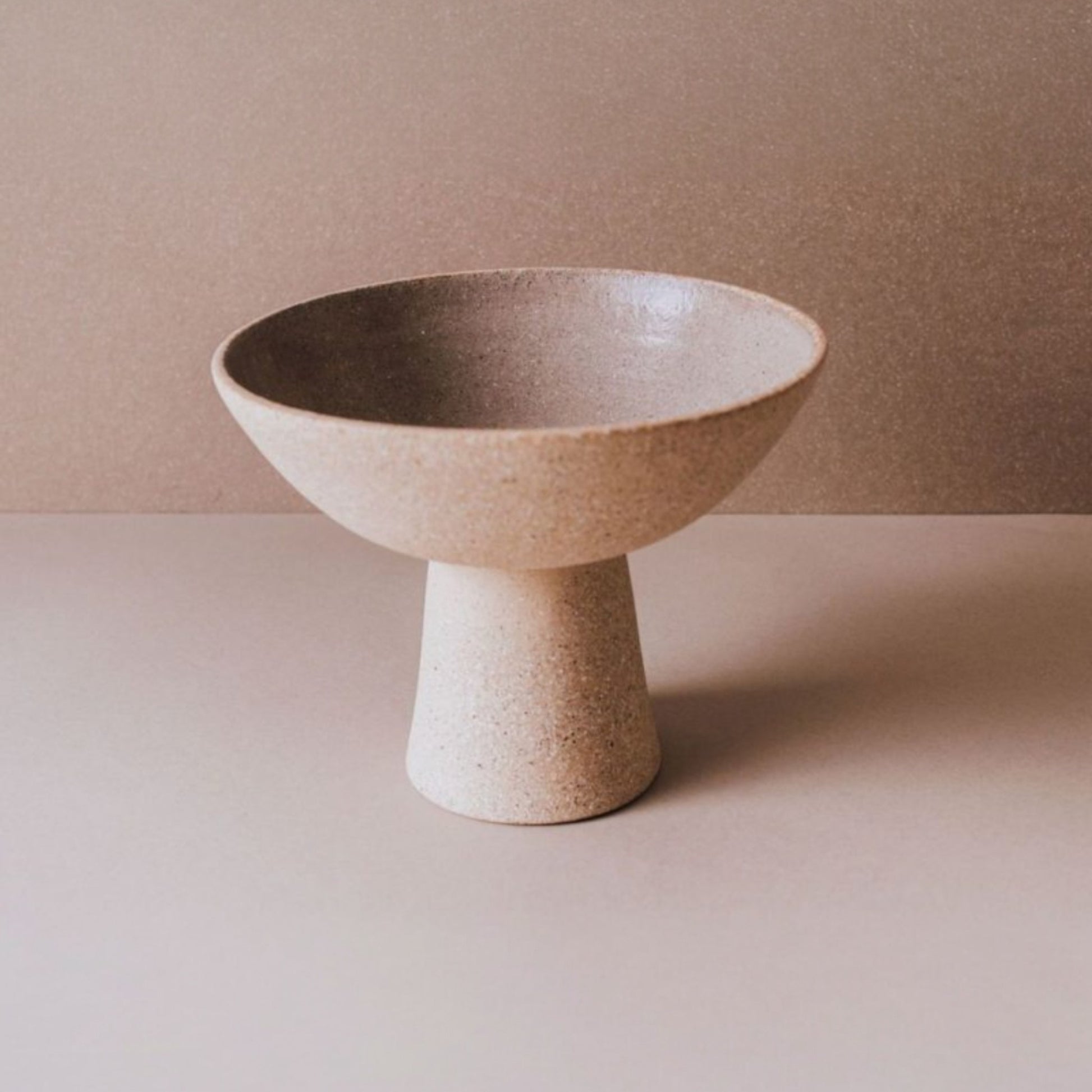 Footed ceramic centerpiece bowl in cork terracotta with minimalist sculptural silhouette