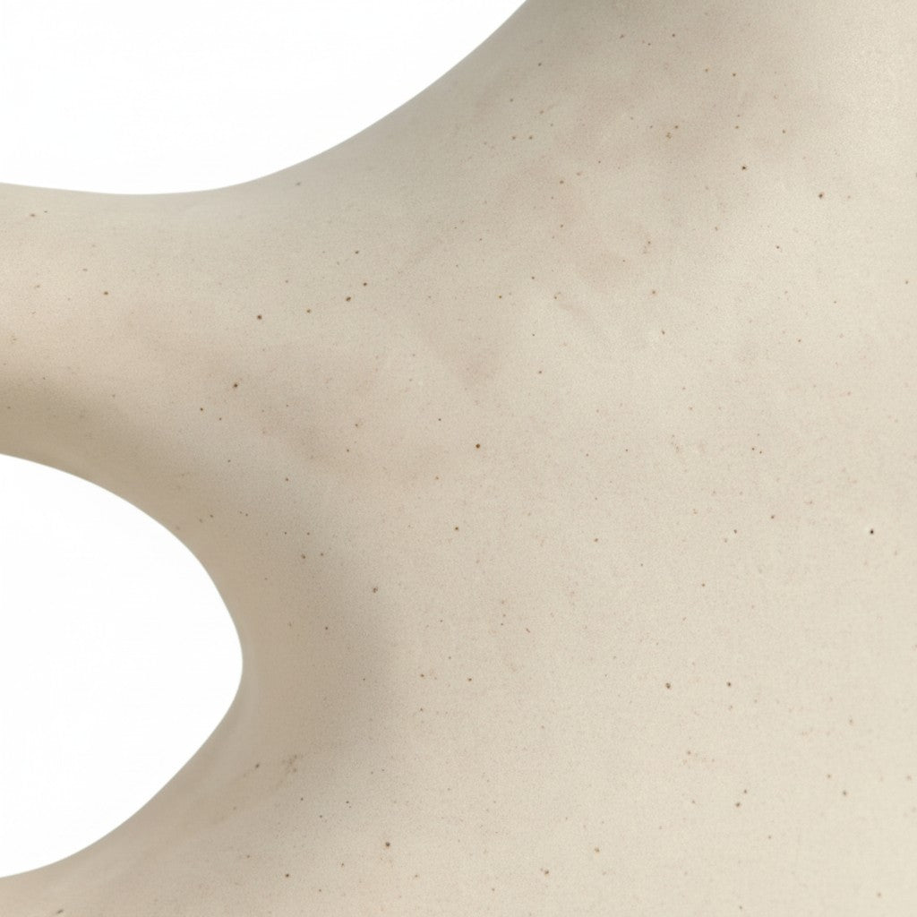 Detail shot of off-white sculptural vase showing natural ceramic texture and curved form.