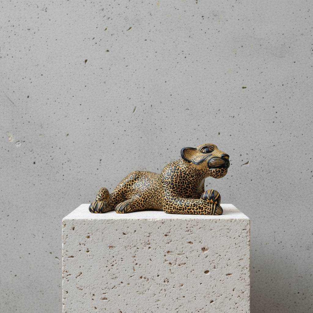 Reclining clay jaguar figurine hand-painted with mineral pigments, crafted in Amatenango del Valle, Chiapas, on a concrete pedestal