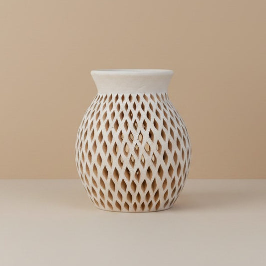 Handmade white clay vase with hand-carved diamond-cut openwork pattern, from Santa María Atzompa, Oaxaca, on a soft beige background