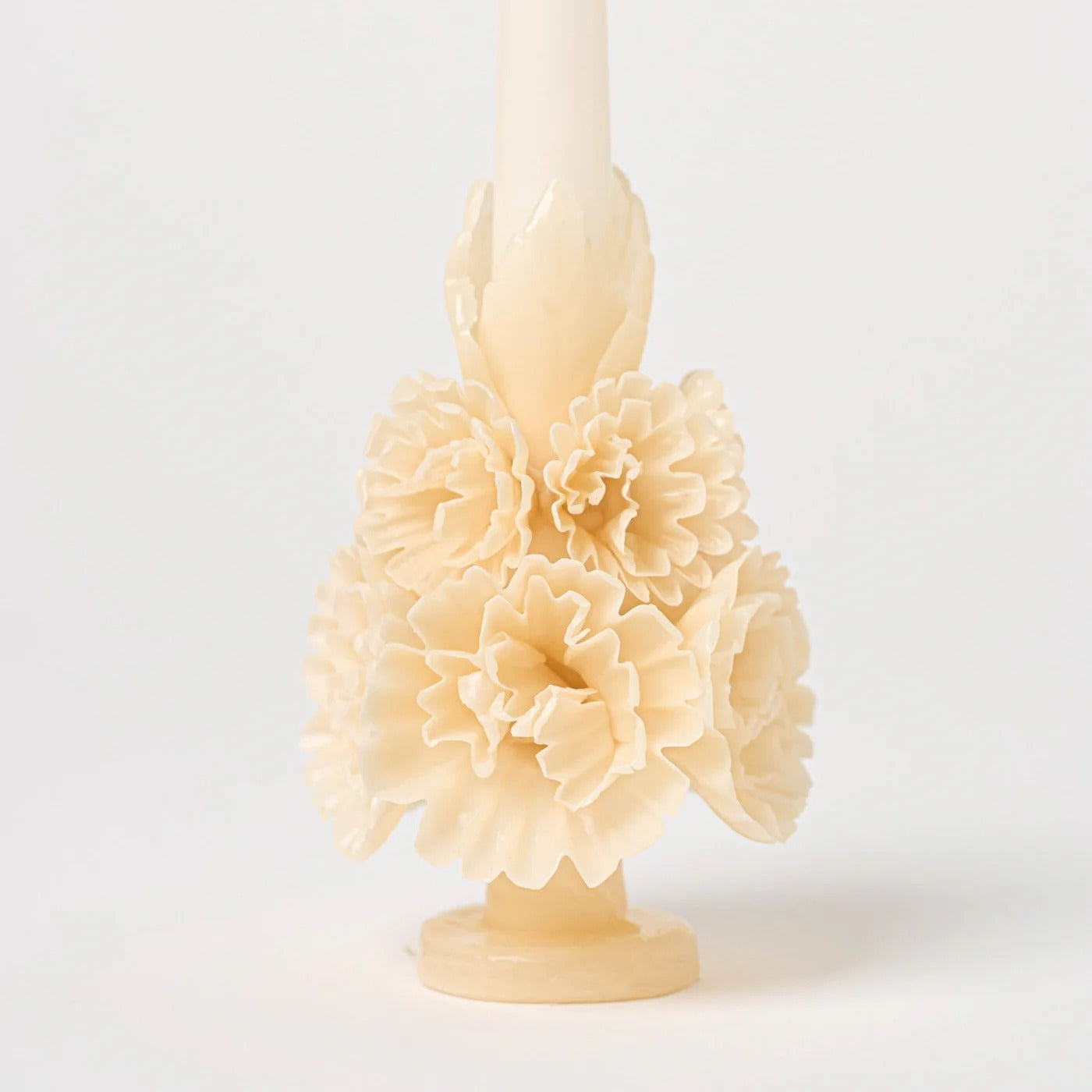 Close-up of ivory carved beeswax candle showing detailed floral petals and hand-sculpted texture