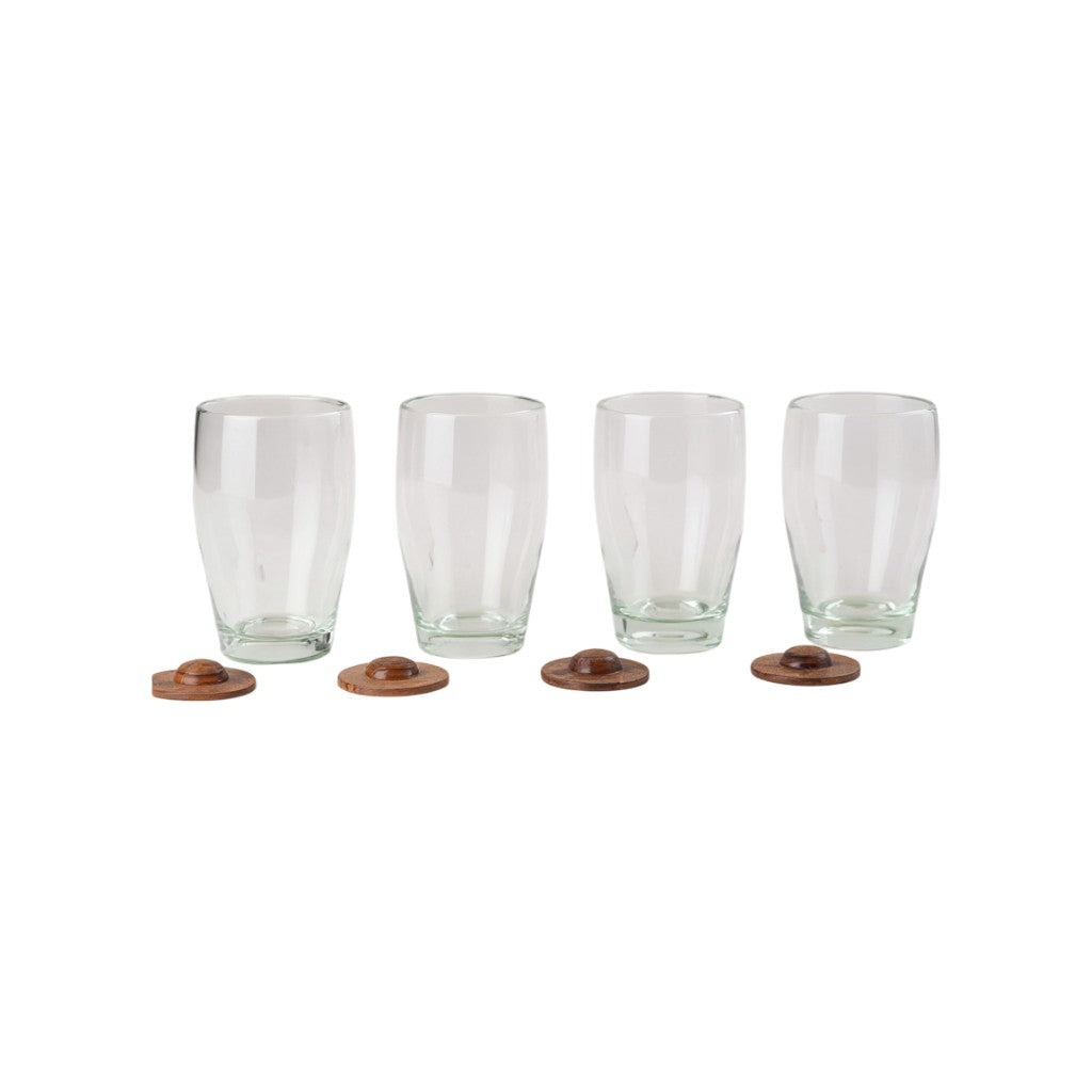Set of four clear glass tumblers paired with parota wood coasters arranged in a row on a white background.